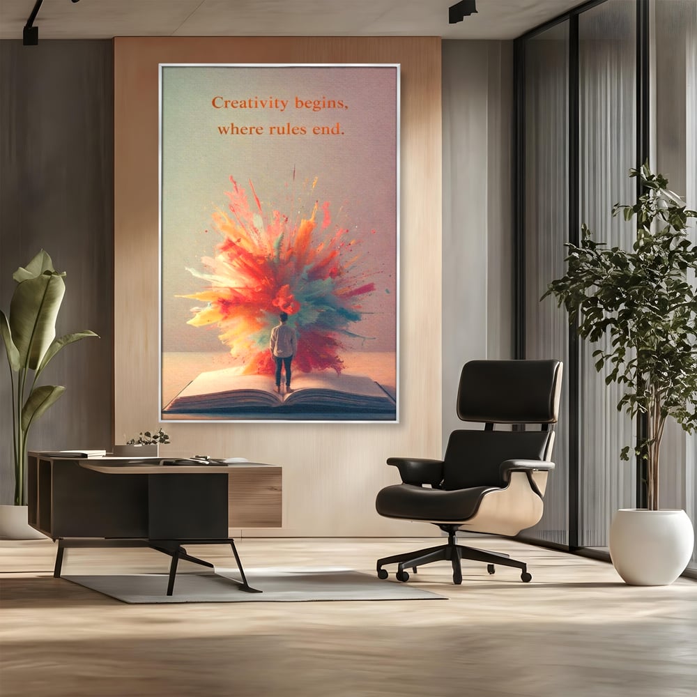 Tablou canvas cu tablou canvas cu barbat privind o explozie de culoare dintr-o carte deschisa, in rama de aluminiu argintiu, pe perete intr-un birou